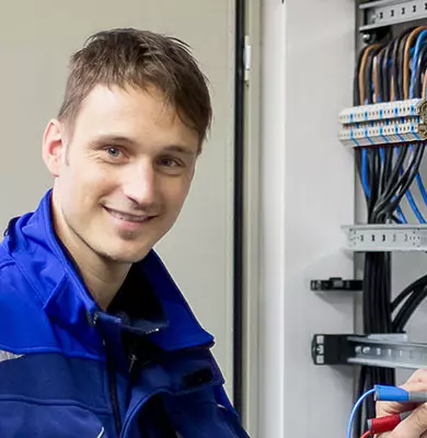 Ein Sachverständiger für Elektrotechnik vor einem geöffneten Schaltschrank