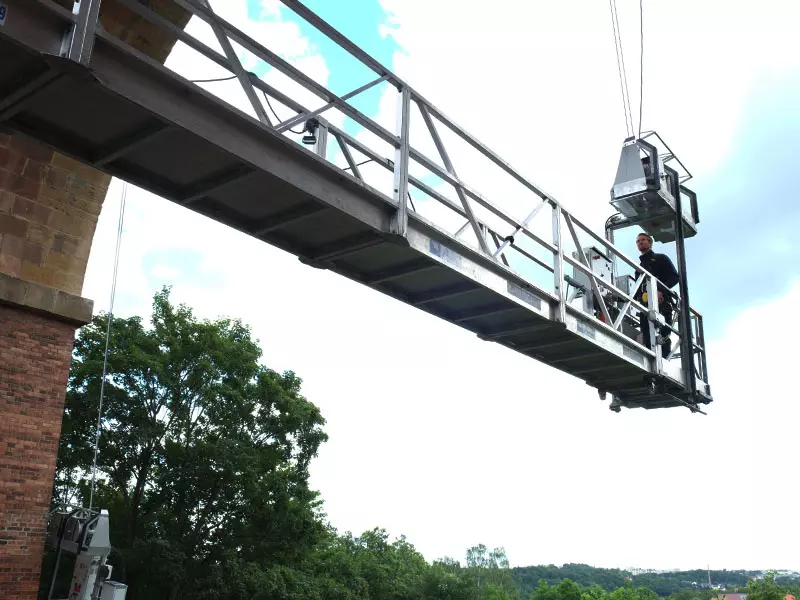 Ein Prüfer arbeitet in großer Höhe an einer Brücke